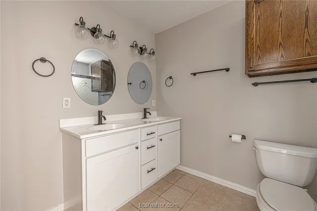 a bathroom with a toilet sink and mirror