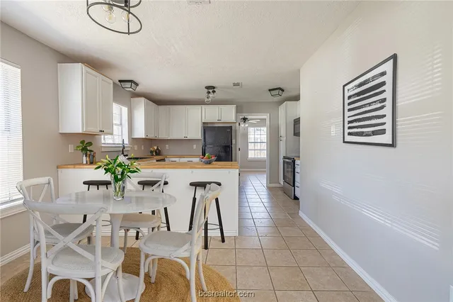 a dining room with furniture and kitchen view