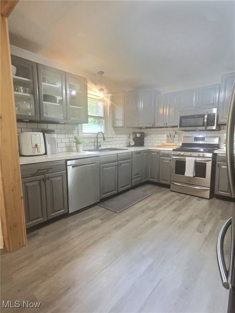 3688 Easton Road Norton, OH 44203 - Photo 15 of 37 Kitchen with appliances with stainless steel finishes, gray cabinetry, sink, and light hardwood / wood-style floors