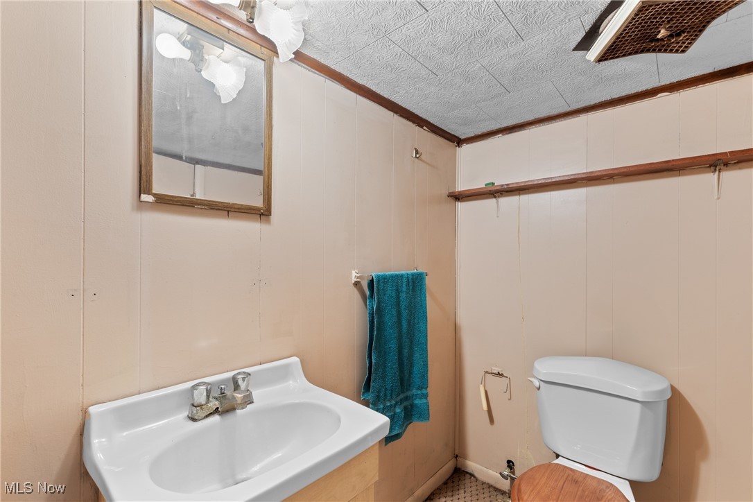 8 Spring Street Bridgeport, OH 43912 - Photo 21 of 34 Half bathroom with wooden walls and ornamental molding