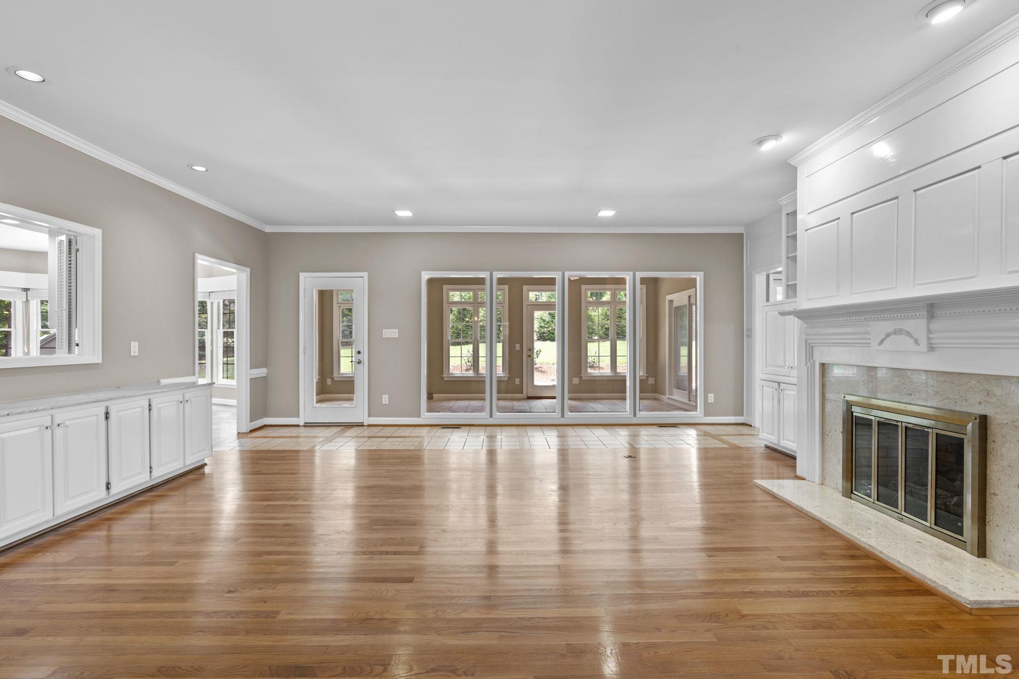 2417 Beechview Court Raleigh, NC 27615 - Photo 8 of 43 an empty room with wooden floor and fireplace