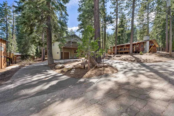 a view of a house with backyard and trees