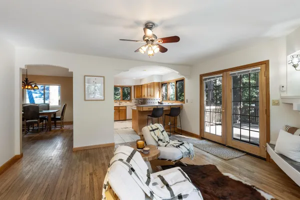 a living room with furniture two window and wooden floor