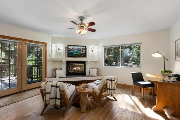 a living room with furniture a fireplace and a large window