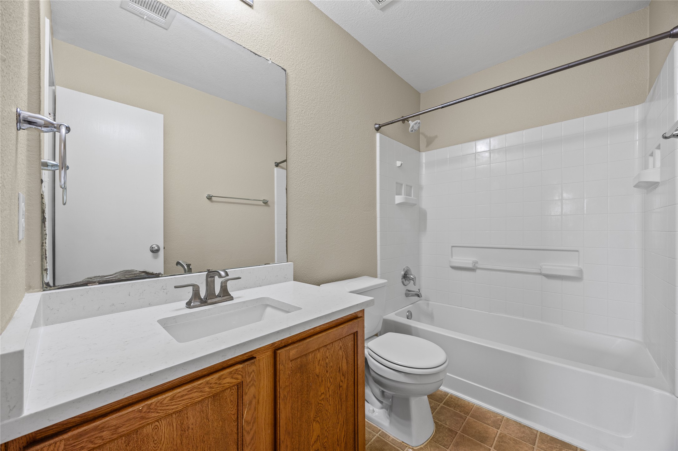 198 Black Forest Road Buda, TX 78610 - Photo 14 of 23 A well-appointed bathroom features a single vanity, a standard tub, and a shower with white tile.