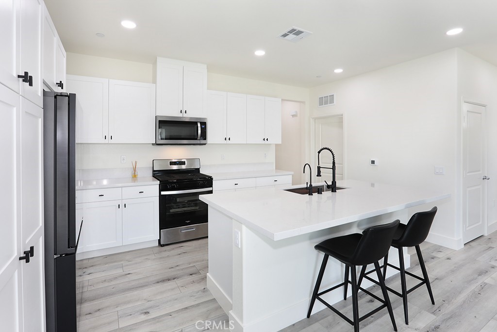 4067 Summer Corona, CA 92883 - Photo 11 of 28 a kitchen with a sink cabinets and refrigerator