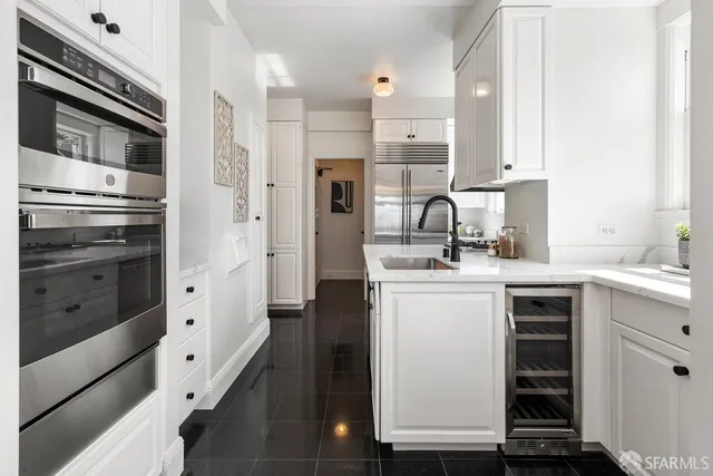 a kitchen with white cabinets and stainless steel appliances