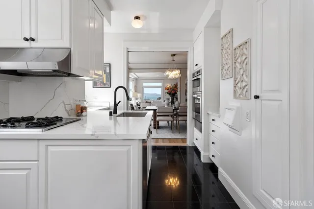 a kitchen with stainless steel appliances a sink a stove and a refrigerator