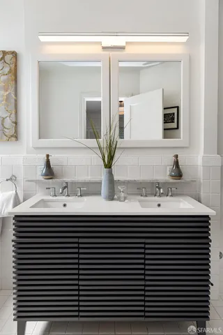 a bathroom with a double vanity sink and a mirror