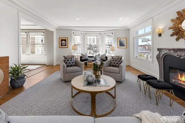 a living room with fireplace furniture and a large window