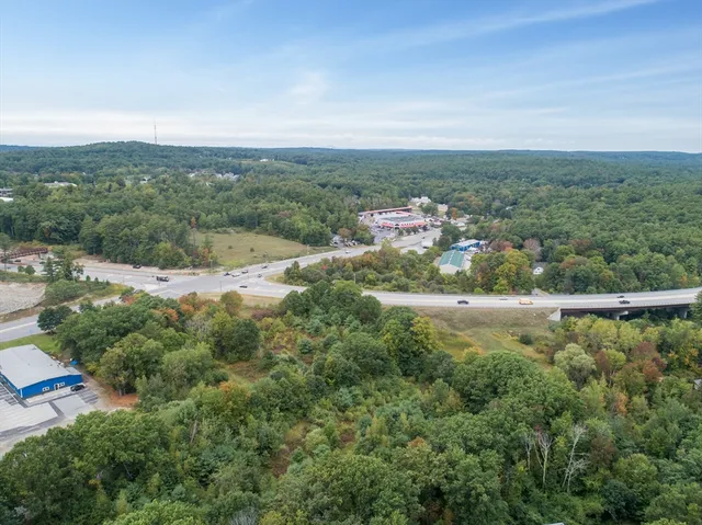 an aerial view of residential houses with outdoor space and trees