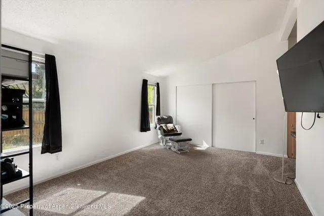 a view of a room with gym equipment and a flat screen tv