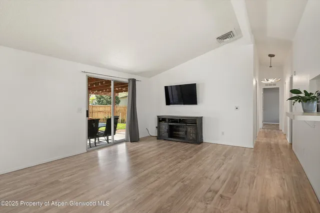 a view of an empty room with a fireplace and a window