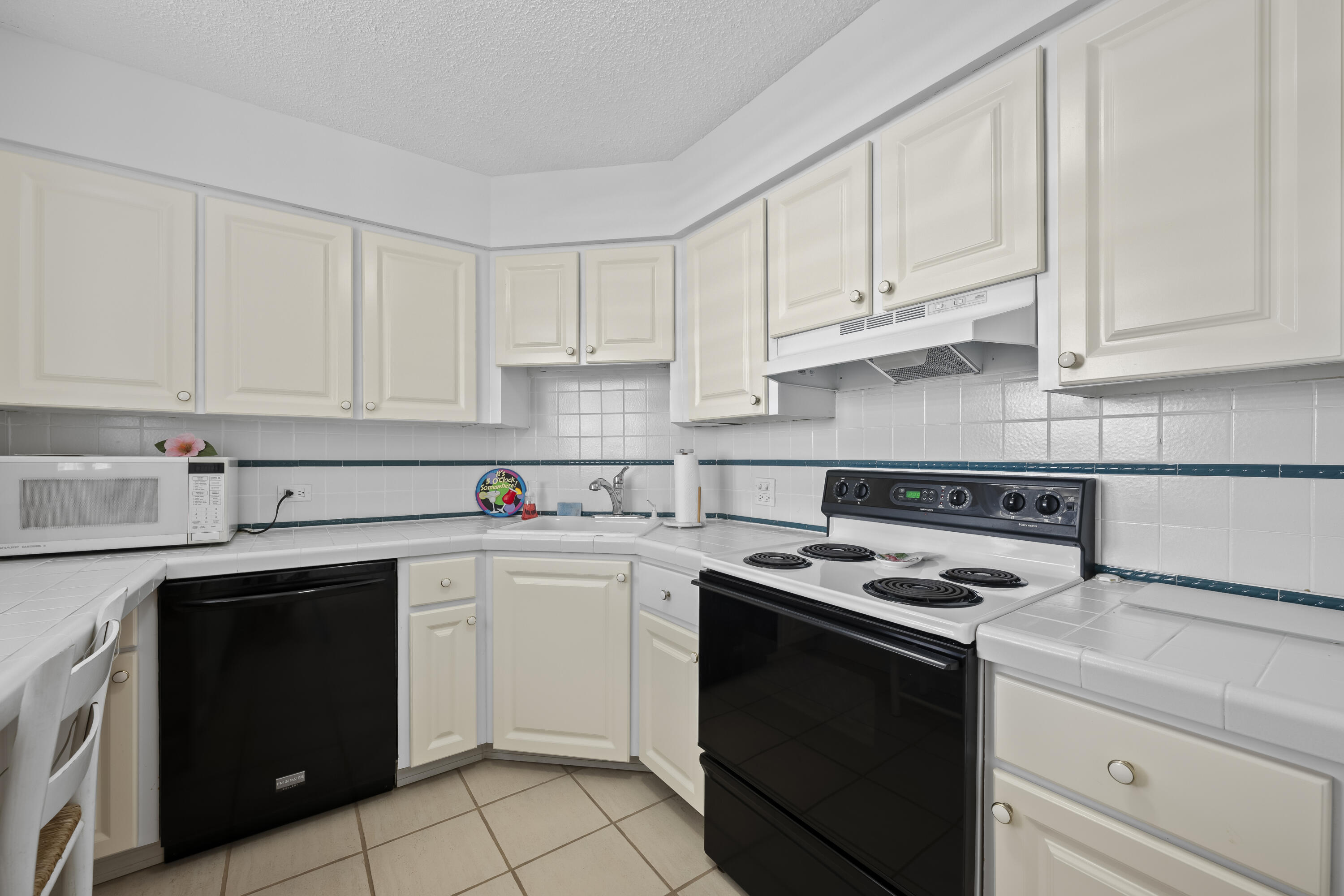 134 Lakeshore Drive, Unit 814 North Palm Beach, FL 33408 - Photo 11 of 30 a kitchen with white cabinets and white appliances