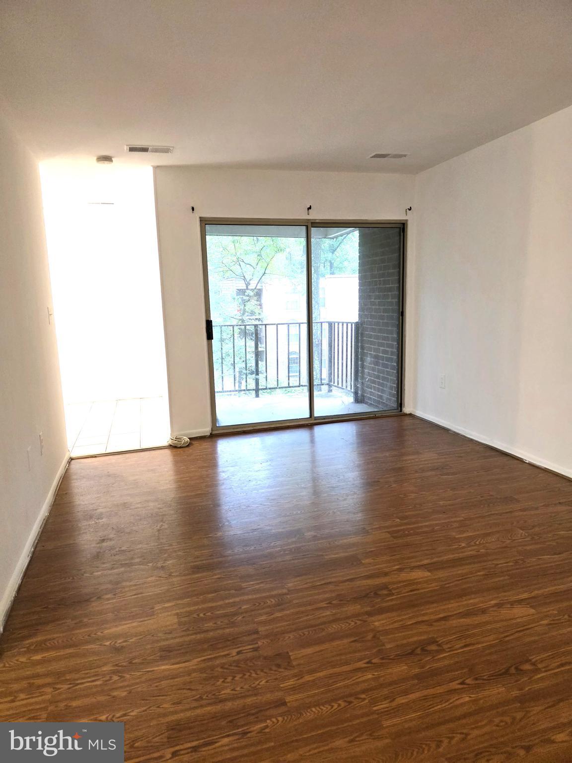 3376 Woodburn Road, Unit 32 Annandale, VA 22003 - Photo 10 of 21 a view of an empty room with wooden floor and a window