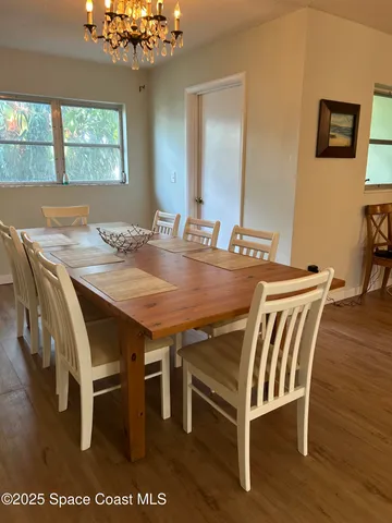 a view of a dining room with furniture and a chandelier