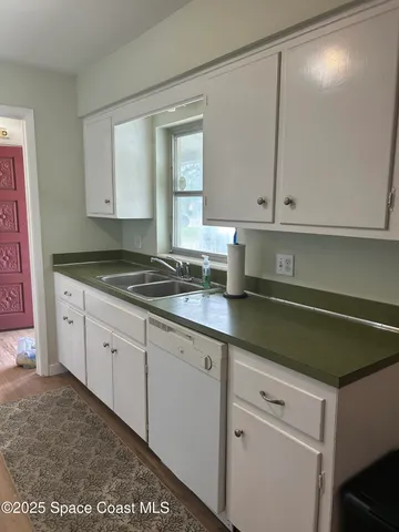 a kitchen with granite countertop white cabinets and white appliances