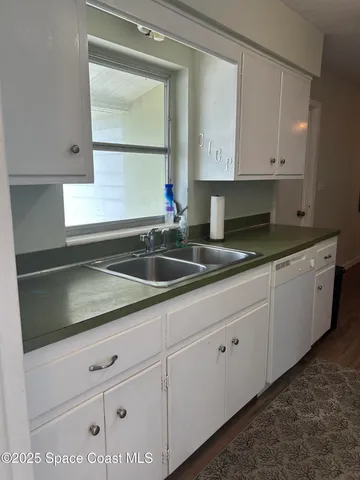 a kitchen with white cabinets and a sink