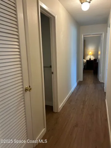 a view of a hallway with wooden floor