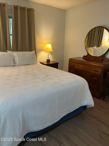 a bedroom with a bed and teddy bear on table