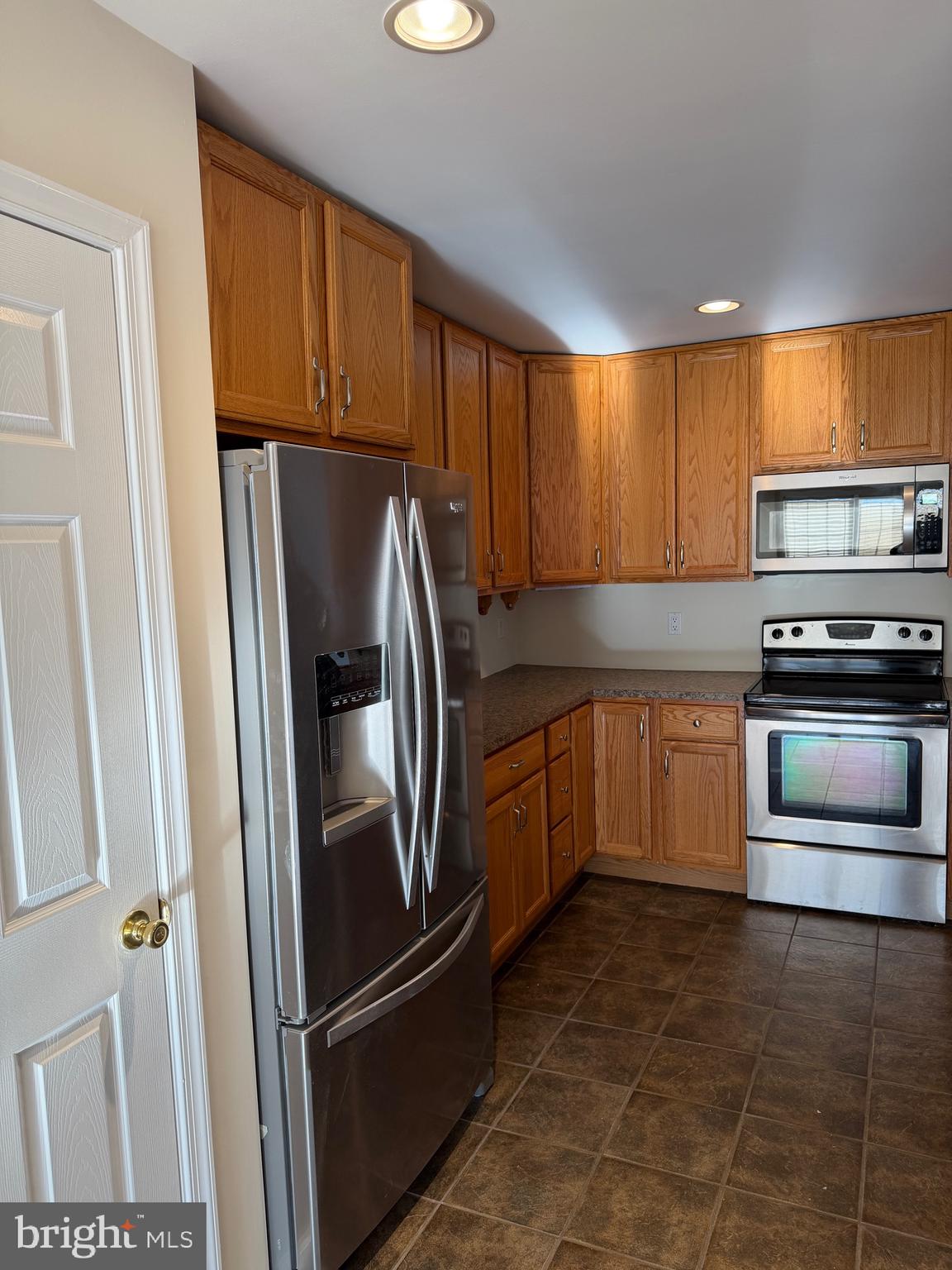 32841 East Riga Drive Ocean View, DE 19970 - Photo 8 of 33 a kitchen with granite countertop a refrigerator and a stove top oven