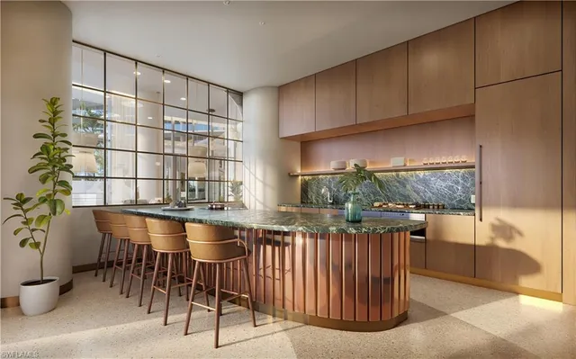 a kitchen with granite countertop a table chairs stove and cabinets