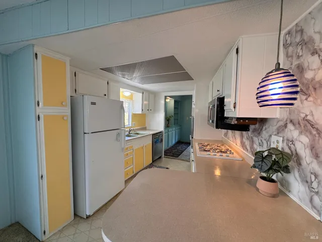 a kitchen with refrigerator and cabinets