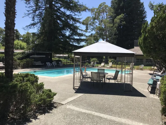 a backyard of a house with fountain table and chairs