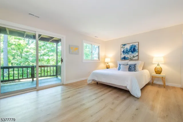 a spacious bedroom with a bed and wooden floor