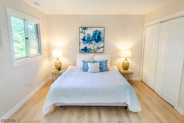 a bedroom with a bed and wooden floor