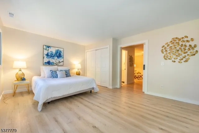 a bedroom with a bed and a painting on the wall