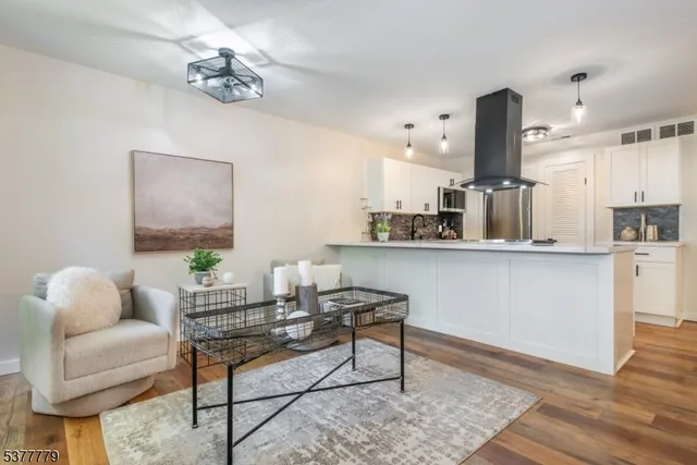 a living room with furniture and kitchen view