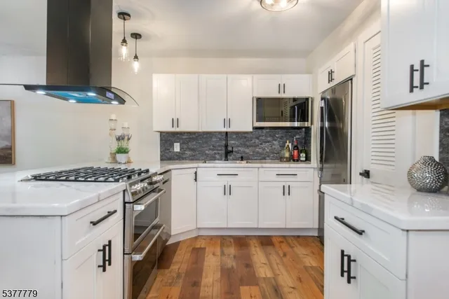 a kitchen with white cabinets and appliances