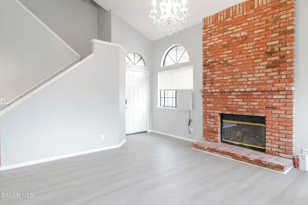 an empty room with windows fireplace and sink