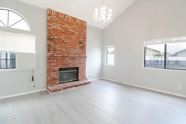 wooden floor fireplace and windows in an empty room