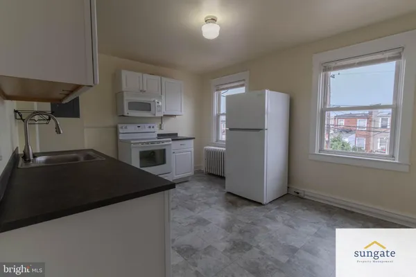 a kitchen with a refrigerator and a stove top oven