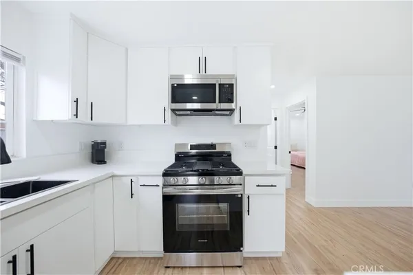 a kitchen with stainless steel appliances a stove a microwave and sink