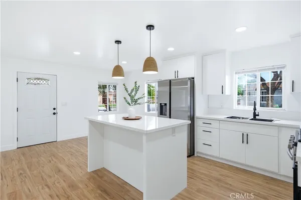 a kitchen with stainless steel appliances a sink stove and refrigerator