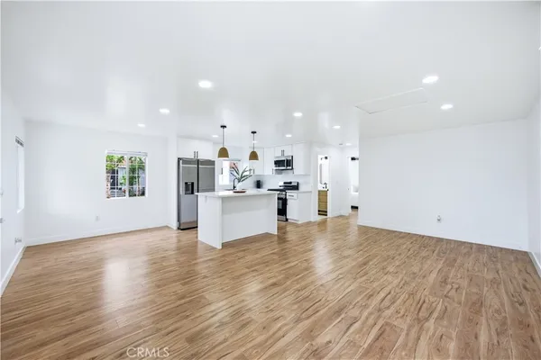 a view of kitchen and kitchen with a sink wooden floor cabinets