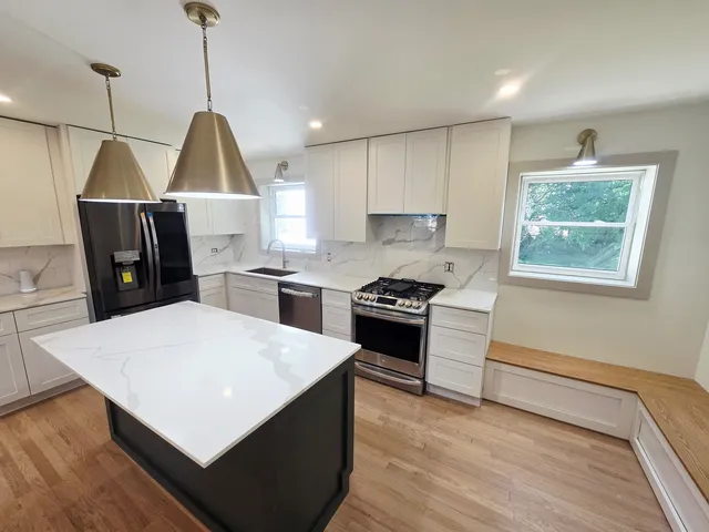 a kitchen with stainless steel appliances a stove a refrigerator and wooden floor