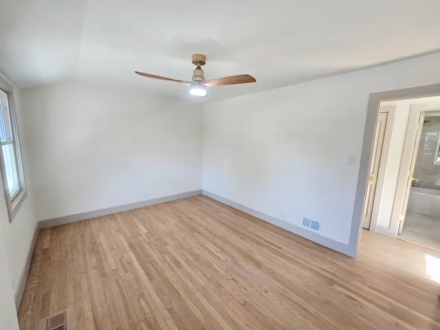 an empty room with wooden floor and window