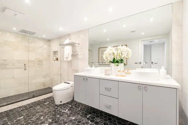 a bathroom with a double vanity sink toilet and shower