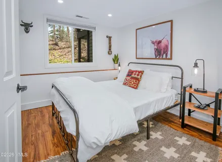 a bedroom with a bed and a painting on the wall