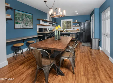 a view of a dining room with furniture a chandelier and wooden floor