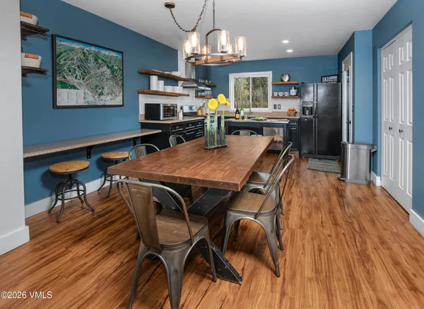 a view of a dining room with furniture a chandelier and wooden floor