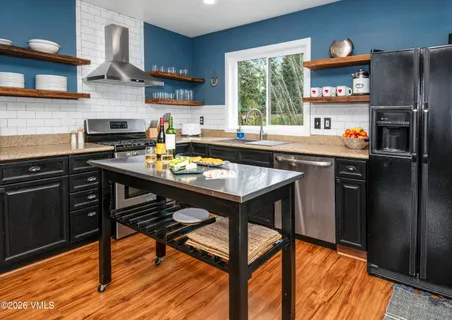 a kitchen with stainless steel appliances granite countertop a stove refrigerator and cabinets