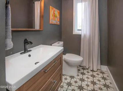 a bathroom with a sink a toilet and mirror