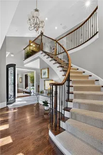 a dining room with furniture a chandelier and wooden floor