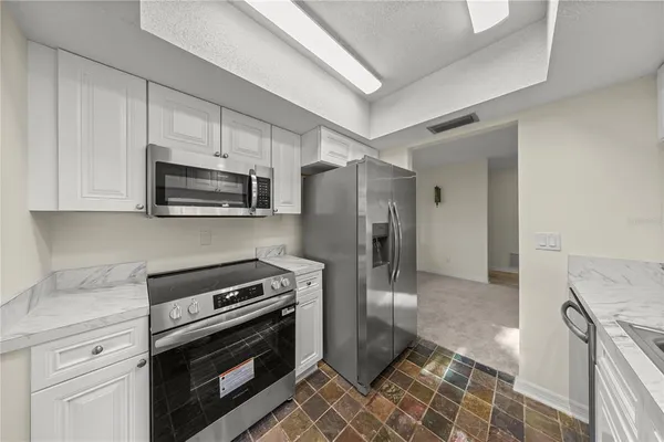 a kitchen with a refrigerator stove and microwave