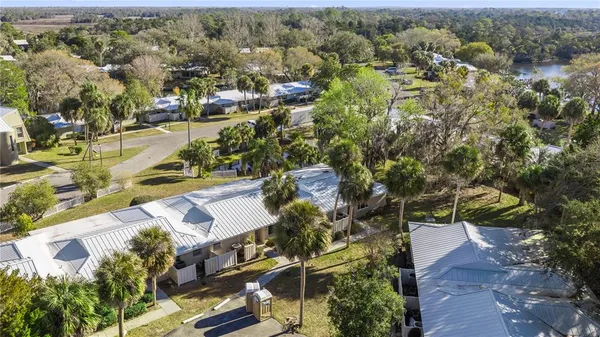 an aerial view of residential houses with outdoor space and trees